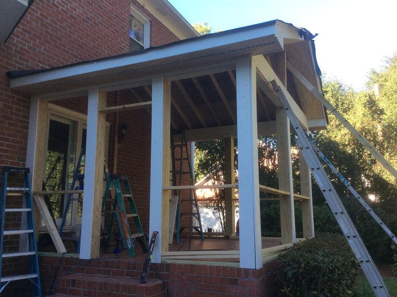 The screened porch under construction with framing and roof going up