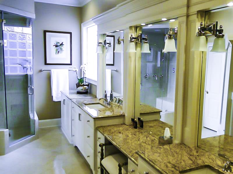 Remodeled master bath with a granite vanity and framed columns
