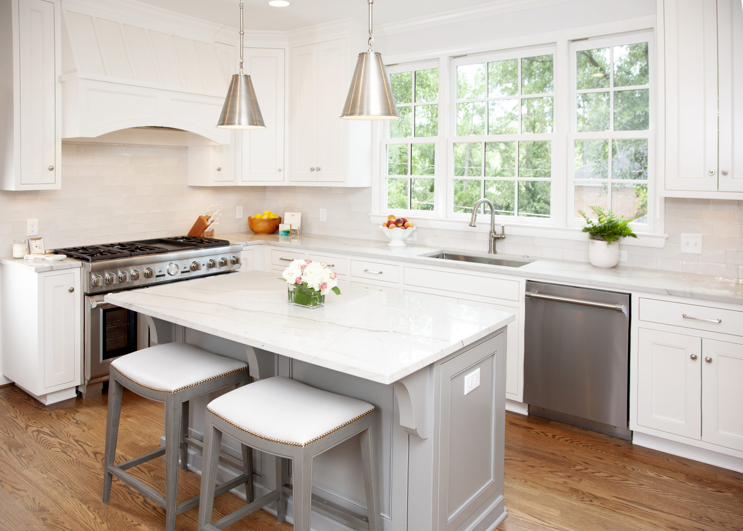 White kitchen with a grey island and counter stools
