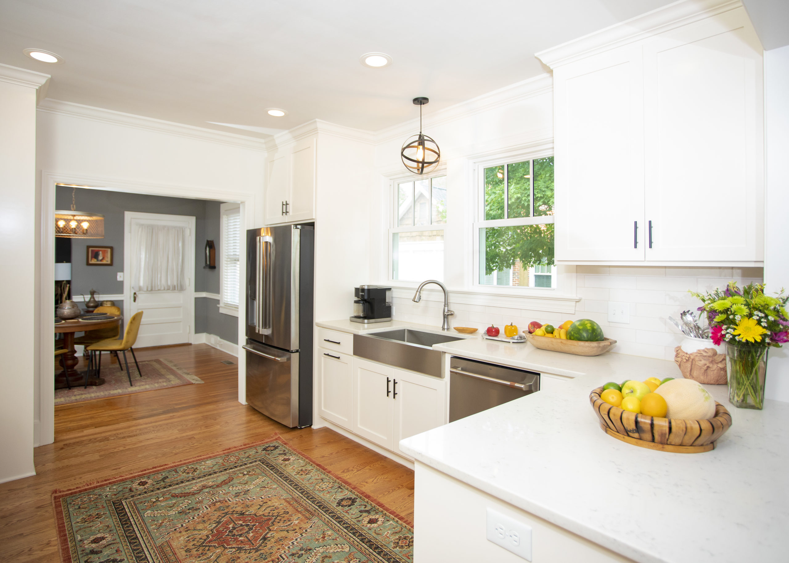 White kitchen nook with a farmhouse sink at the window