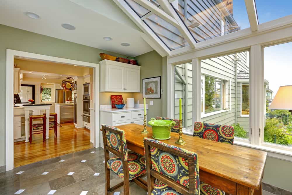 Sunroom addition with a wood ceiling and colorful chairs